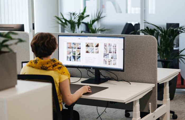 Ein Mensch sitz im Büro und arbeitet am Laptop